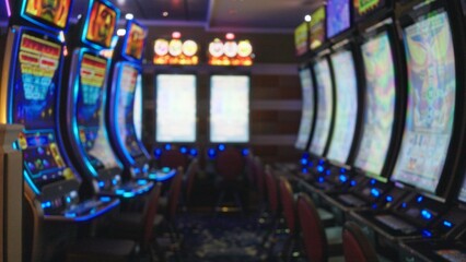 Blurred view of brightly lit slot machines in a colorful las vegas casino, capturing the vibrant indoor atmosphere. © Krakenimages.com