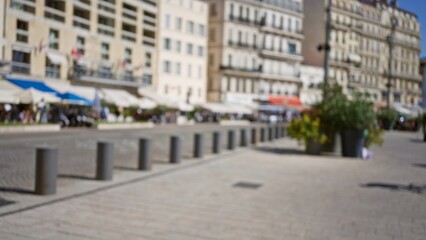 Blurred street scene in marseilles with buildings and pedestrians in the european outdoor setting, showcasing urban life with defocused elements and bright light.