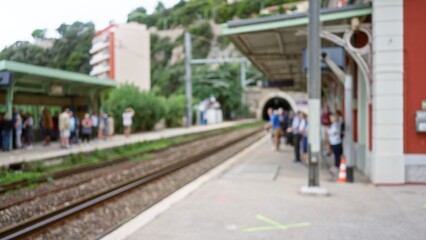 Crowd waiting on platform at train station with blurred commuters and defocused background, capturing dynamic bokeh effect in busy urban setting