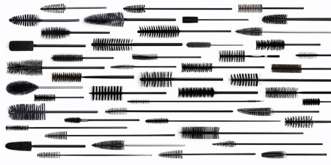 Mascara smudge stroke swatches and applicator brushes set isolated on white background. Smears of make-up cosmetic eyelash mascara, top view.