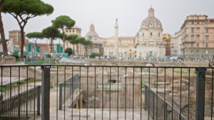 Blurred view of ancient ruins in rome with bokeh effect highlighting historic architecture in the roman forum under cloudy skies.