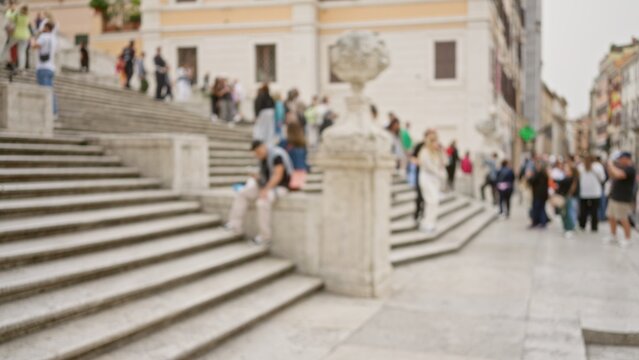 Blurred tourists explore the historic spanish steps in rome, italy, with out-of-focus architecture and lively crowd creating a sense of bustling energy in piazza di spagna.