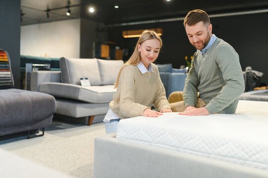 Couple choosing sofa and pillows at furniture store