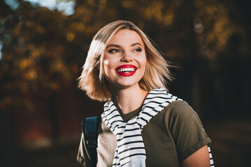 Photo of attractive young cheerful lady look wondered smile wear khaki garment tied shoulders...