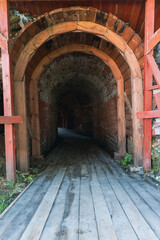 Entrance to dark wooden and stone tunnel in historic fortress