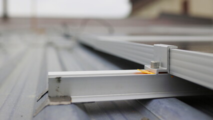 Close up of mounting solar panel, installing solar panels on dau house. Fixing and connection of modern solar panels. Rows of sustainable energy solar panels installed on terrace.