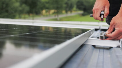 Mounting solar panel, installing solar panels on the roof of the house. Connection of solar panels. Close up of worker installing and working on maintenance of photovoltaic panel system installed