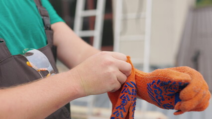 POV Worker put on Yellow Gloves on Hands. Point of view Diy carpenter prepares for work. Handyman puts on gloves. A man in uniform puts on gloves