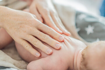 The newborn's skin is peeling. Mom uses skin products and massages to care for and soothe the baby's delicate skin, ensuring comfort and promoting healthy skin