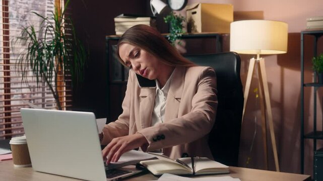Overworked stressed Caucasian business woman female girl businesswoman office worker employer secretary talk mobile phone throwing document paperwork working laptop computer multitasking stress indoor