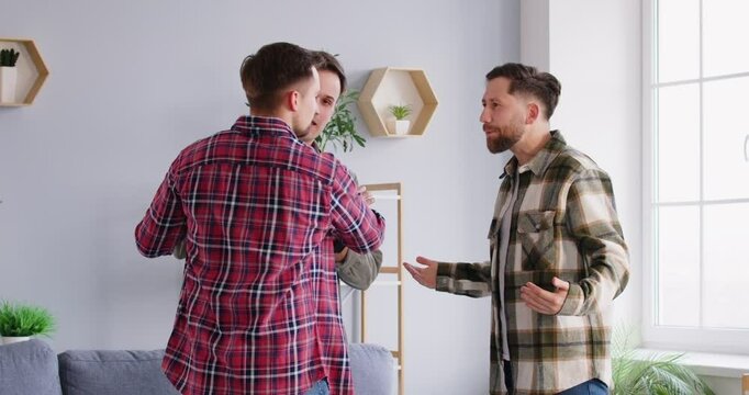 Conflict between men. Young woman mediates and tries to calm an emotional dispute between three male friends. Concept of peaceful resolution of conflicts in everyday situations. 4k video.