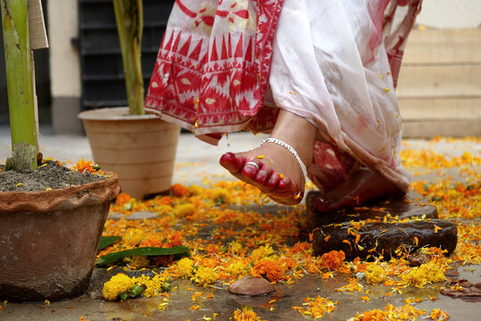 Bengali bride breaking clay pot with her feet as this is traditional rituals of Bengali Marriage
