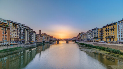 Obraz premium Cityscape view on Arno river with famous Holy Trinity bridge timelapse on the sunset in Florence