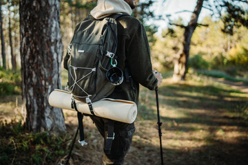 Young caucasian man hiking or trekking through the forest	
