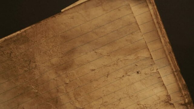 Old and weathered notebook page. Yellow-brown stains and lining. Copy space. background. Unique vintage texture of old paper