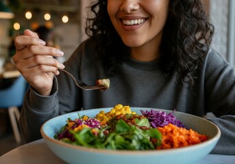 Young woman enjoying a colorful and nutritious vegan buddha bowl in a restaurant setting