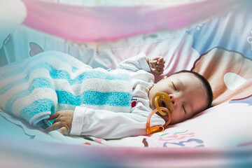 Baby sucking on a rubber pacifier