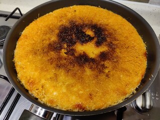 Golden-Brown Knafeh (Kunefe) in a Pan, Freshly Made with a Crispy Top Layer of Shredded Phyllo Dough and a Rich, Sweet Interior, Ready to Serve as a Delicious Middle Eastern Dessert Treat.