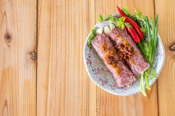Minced pork rice garlic and spices are mixed together and wrapped in a stick form to marinate the food giving it a sour taste because it is a type of Asian food preservation called naem or sour meat.