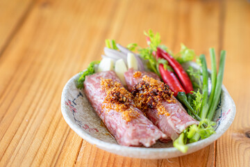 Minced pork rice garlic and spices are mixed together and wrapped in a stick form to marinate the food giving it a sour taste because it is a type of Asian food preservation called naem or sour meat.