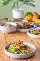 The Khao Soi Yuan Naan that is served on the plate is Khao Soi noodles mixed with minced pork spring onion coriander and chili lime and sesame spicy and sour. noodles chinese food tai yai food