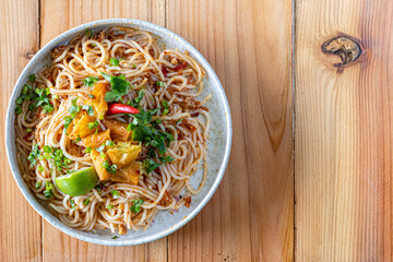 The Khao Soi Yuan Naan that is served on the plate is Khao Soi noodles mixed with minced pork spring onion coriander and chili lime and sesame spicy and sour. noodles chinese food tai yai food