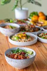 Khao Soi Chiang Tung is served in a bowl with sticky rice noodles and a flavorful soup that is Chiang Tung style. The delicious Khao Soi Chiang Tung is a popular noodle dish among Tai Yai people.