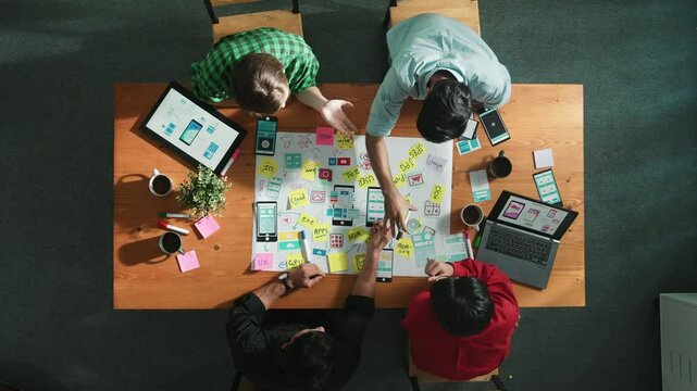 Top view of skilled business team discuss idea about Ux Ui design for mobile phone interface. Smart developer working together to brainstorming and planning software by using mind map. Convocation.