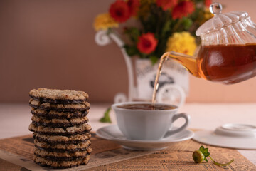 photo Relaxing tea time experience with floral bouquet, featuring elegant porcelain teapot, aromatic herbal infusion, aromatic cookies, delightful decoration, and delicious setup