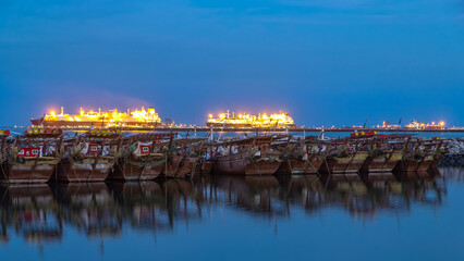 Obraz premium Fishing boat parked near the fish market next to Kuwait City Area day to night timelapse