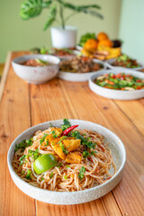 The Khao Soi Yuan Naan that is served on the plate is Khao Soi noodles mixed with minced pork spring onion coriander and chili lime and sesame spicy and sour. noodles chinese food tai yai food