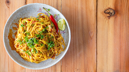 The Khao Soi Yuan Naan that is served on the plate is Khao Soi noodles mixed with minced pork spring onion coriander and chili lime and sesame spicy and sour. noodles chinese food tai yai food