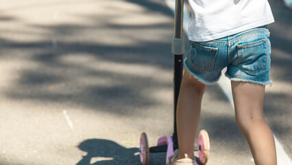 Child riding scooter. Active outdoor fun for kids. Summer sports for children.