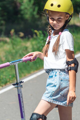 Little girl riding scooter. Kids ride kick board. Child playing on suburban street on sunny summer day. Safe helmet for children. Healthy outdoor activity.