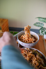 Khao Soi Chiang Tung is served in a bowl with sticky rice noodles and a flavorful soup that is Chiang Tung style. The delicious Khao Soi Chiang Tung is a popular noodle dish among Tai Yai people.