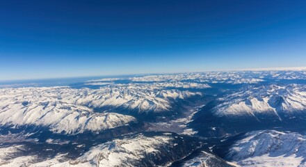 Obraz premium Majestic aerial view of -capped mountain range blue sky