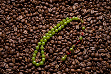 Squeezing Ottoman Turkish Amber Rosary , macro detail shot on coffee beans