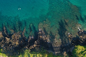 Long Palm Tree shadows on Wailea Maui beach path and shallow reef