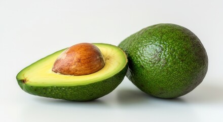 Fresh avocado halves with seed on white background