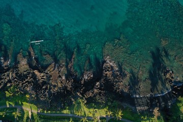 Long Palm Tree shadows on Wailea Maui beach path and shallow reef