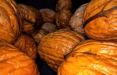 Close-up, macro photography of a pile of walnuts.