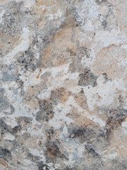 Close-up of natural stone texture with different shades of grey, brown and white. Natural cracks and patterns create a striking and unique texture.