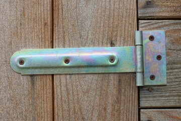 one heavy iron gray long industrial new nailed to wooden boards hung on closed door	