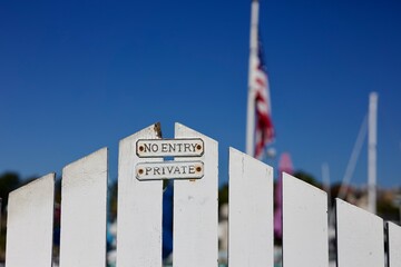 white wood picket fence gate with keep out sign
