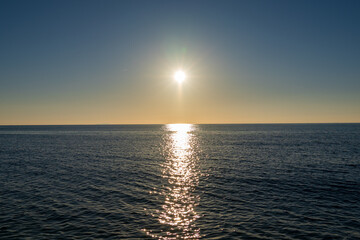 Marina di Pisa, Province of Pisa, Italy - November 4, 2024:  The sun sets against the sea. Reflection of the sun in the sea water.