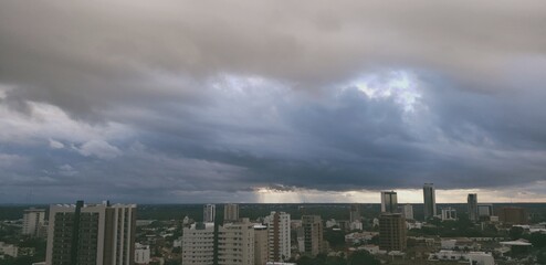 Obraz premium Atardecer de ciudad nublada con haces de luz 
