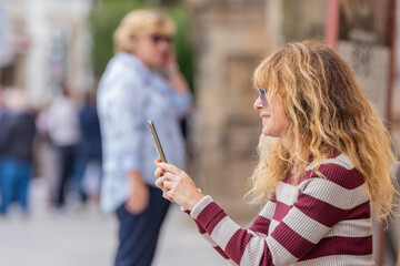 middle aged adult woman on the street with mobile phone