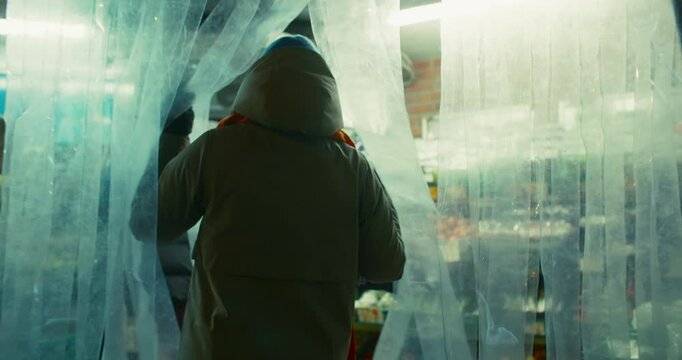 Woman walks into street outdoor stall of vegetable and fruit shop to do some grocery shopping. Cinematic every day life shot of buying local produce