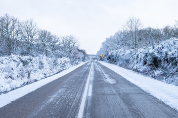 icy road in an frozen landscape during a winter snowfall