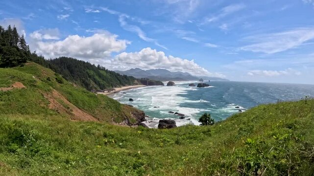 Hyper-lapse of shoreline Ecola State Park with green vegetation under a sunny sky